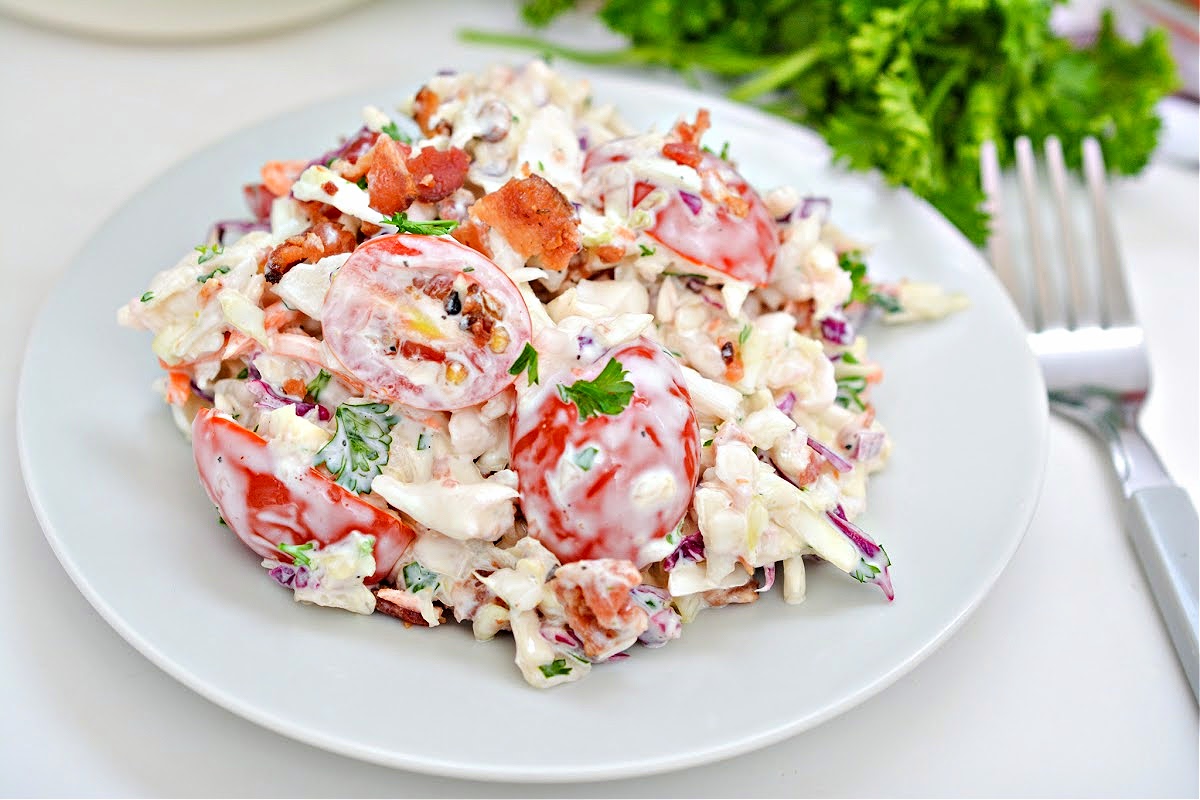 Keto BLT Coleslaw on a white plate with a silver fork