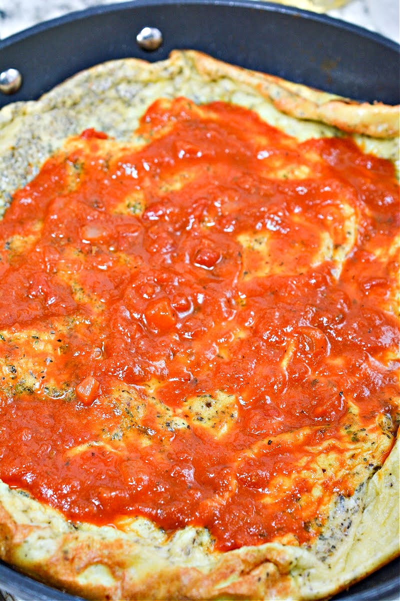 Adding marinara sauce to Keto Italian Sausage Pizza Frittata