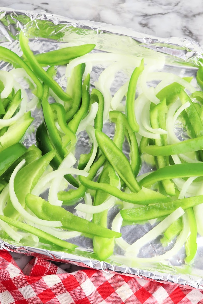 Sliced pepper and onions on a sheet pan