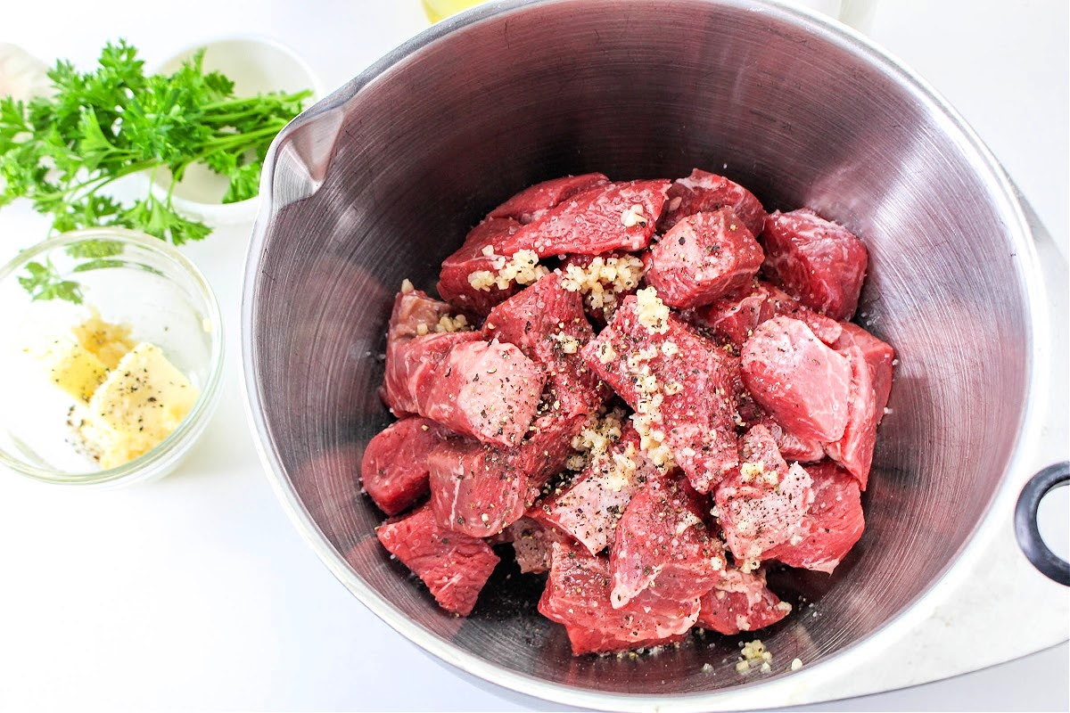 Adding spices to the raw steak bites