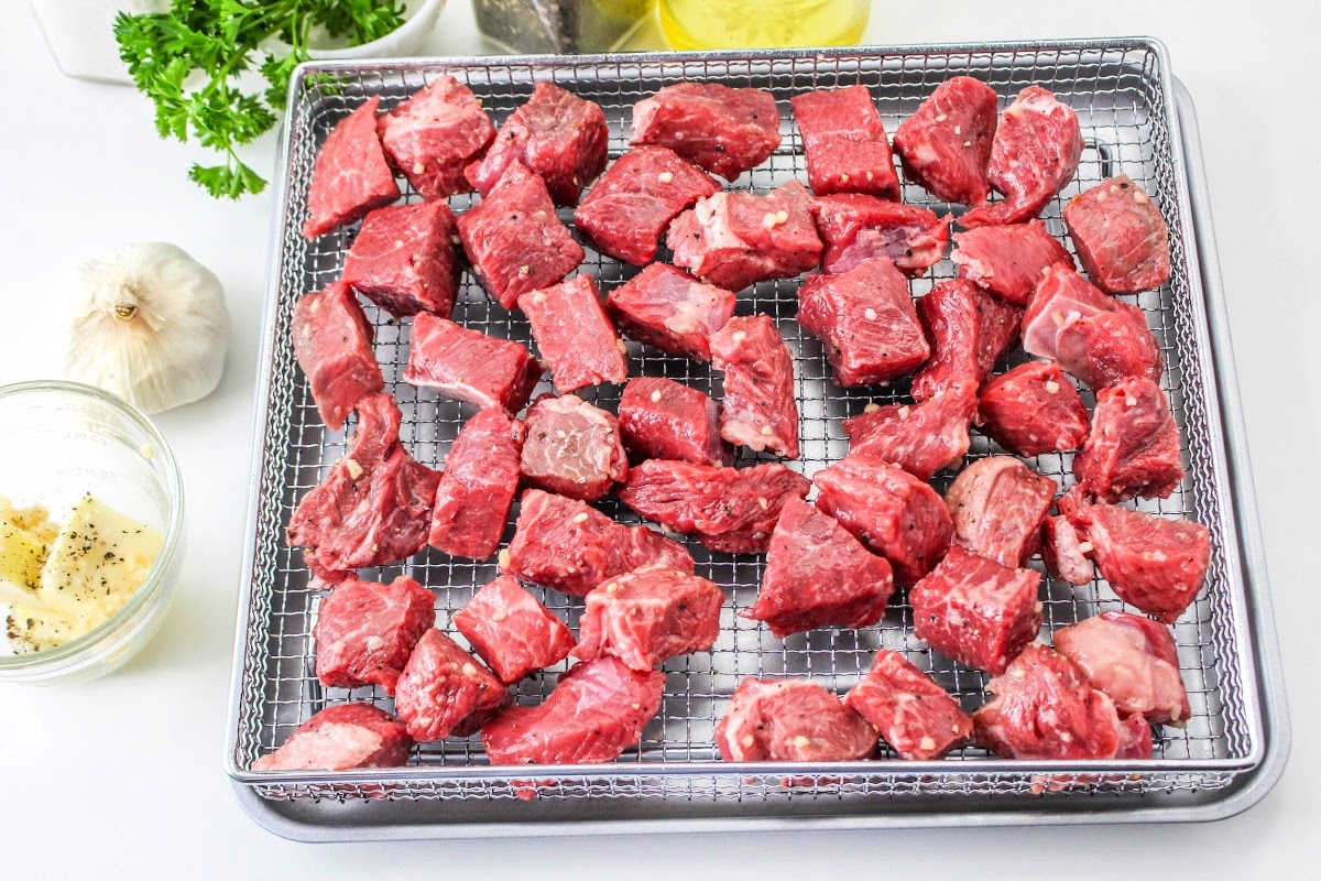 raw steak bites in an air fryer basket